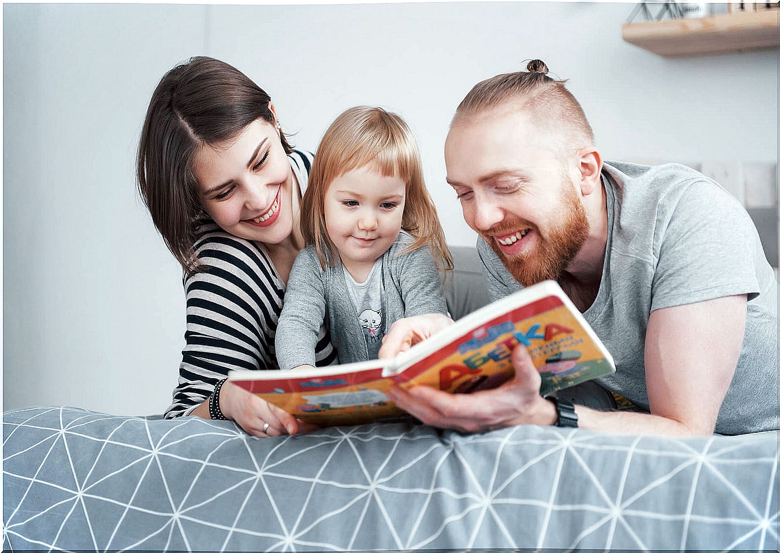 Parents telling stories to their daughter as part of interactive activities to improve language.