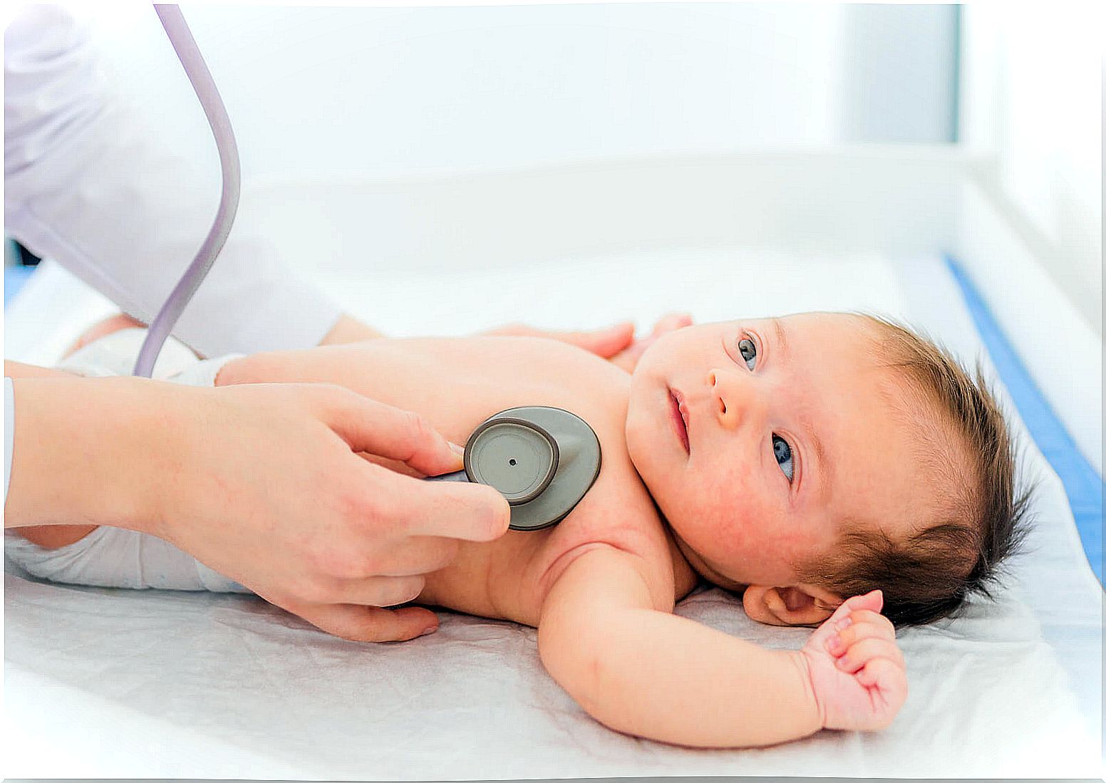 Pediatrician listening to a baby's heart to check for a murmur.