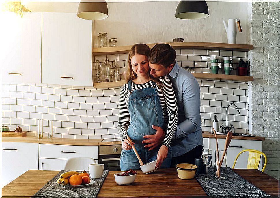 Pregnant woman cooking with her partner following basic food safety regulations.