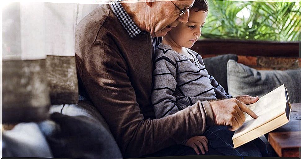 Grandfather reading a children's poetry book to his grandson.