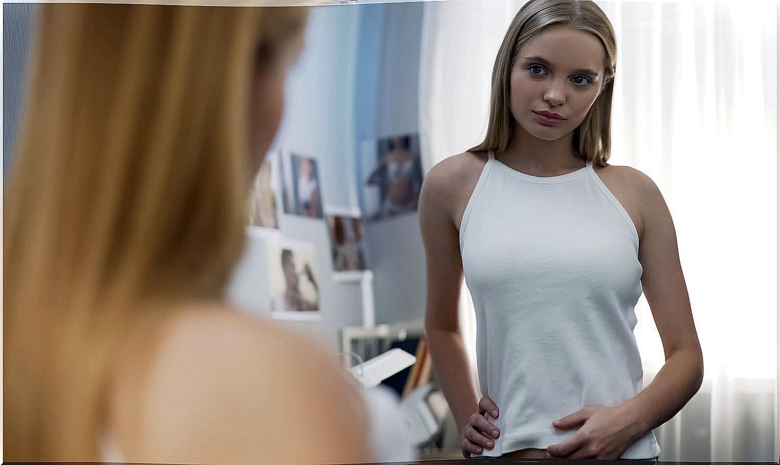 Teen girl looking in the mirror.