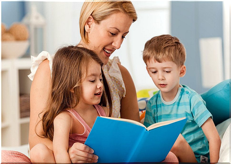 Mother reading children's books to her children to cope with boredom in quarantine.