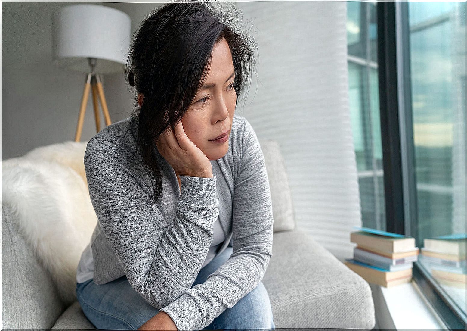 Woman with depression sitting on the couch.