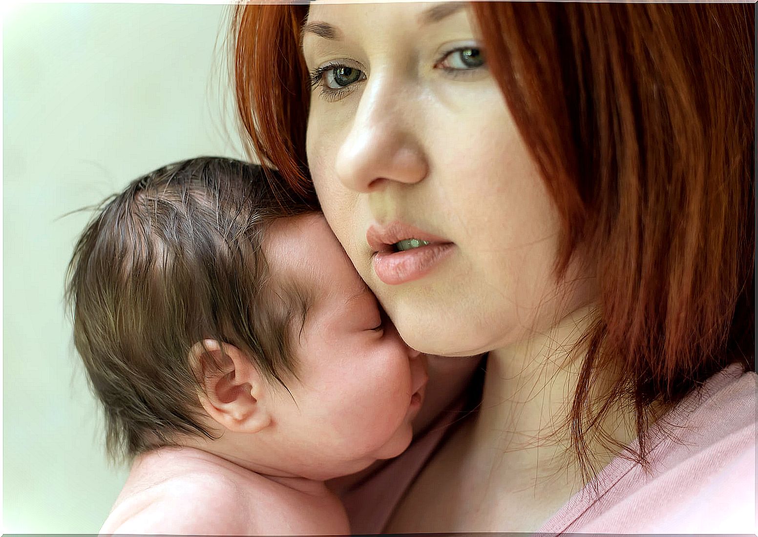 Woman with her newborn at home suffering from depression because she is staying at home.