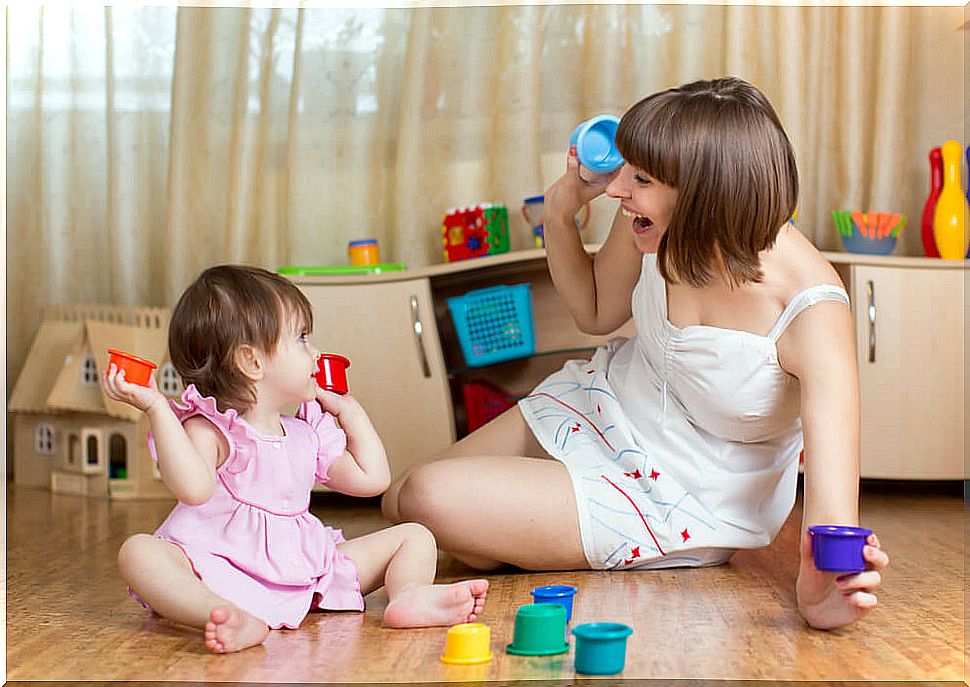 Mom playing with her little girl and doing early stimulation exercises.