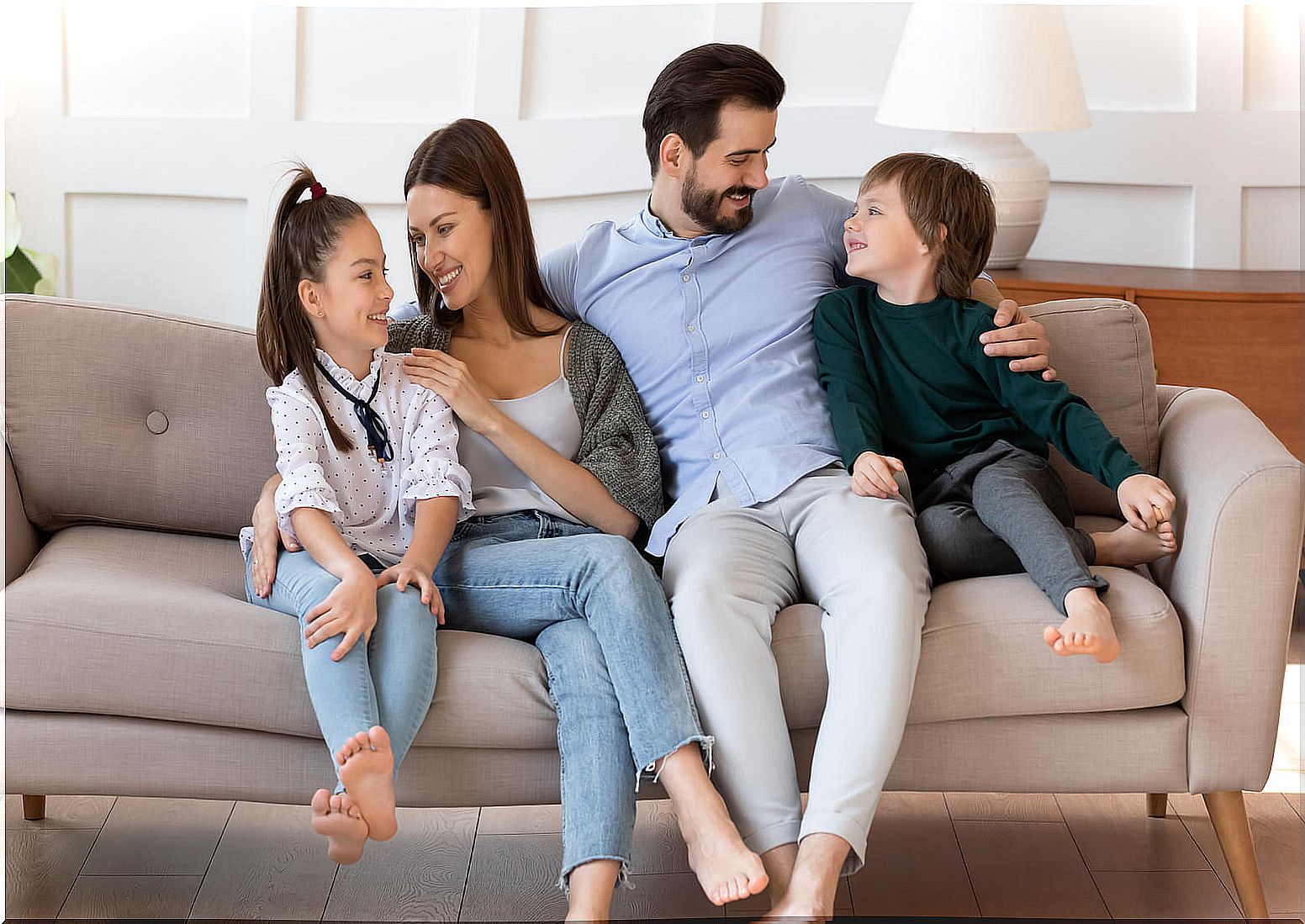 Father talking with his children on the sofa and carrying out the AEIOU method of education.