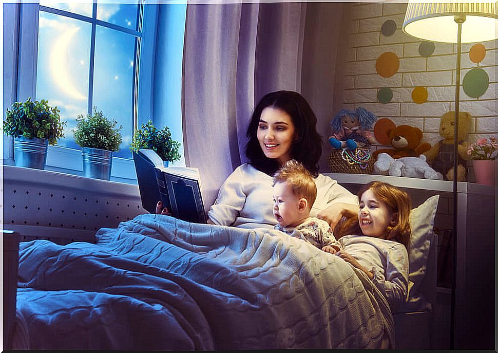 Mother reading Goodnight Stories for Rebellious Girls to her children before going to sleep.