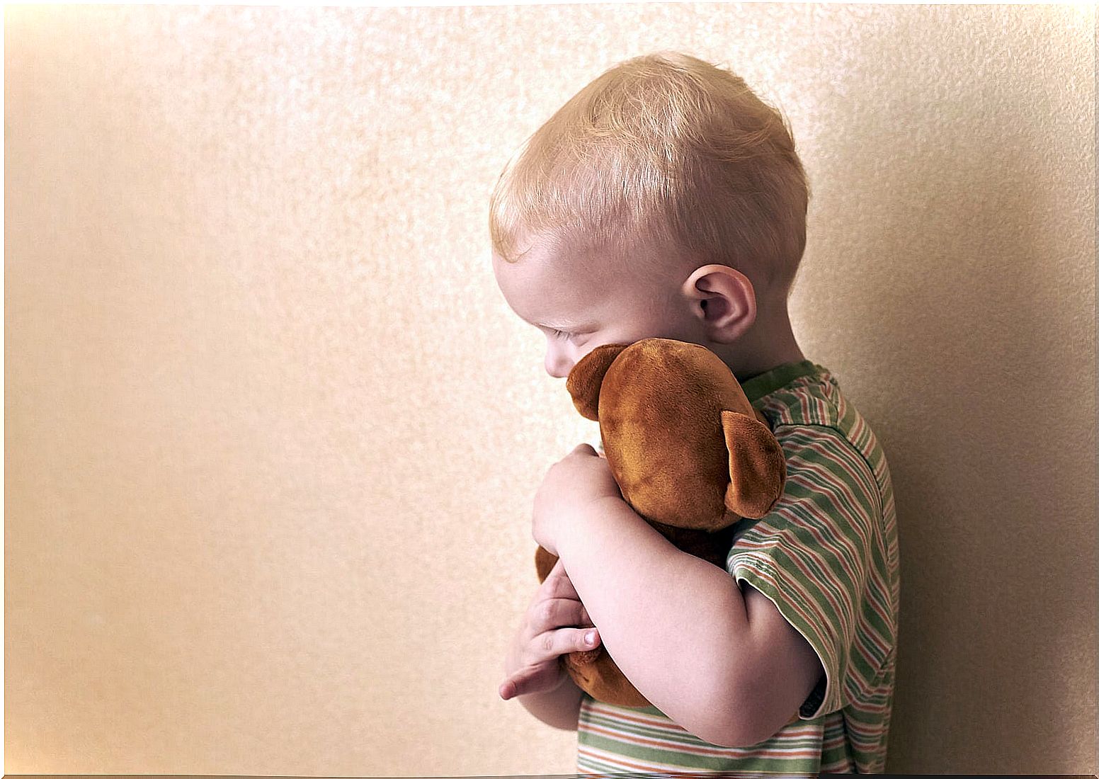 Boy hugging a stuffed animal to try to dismantle his fears.