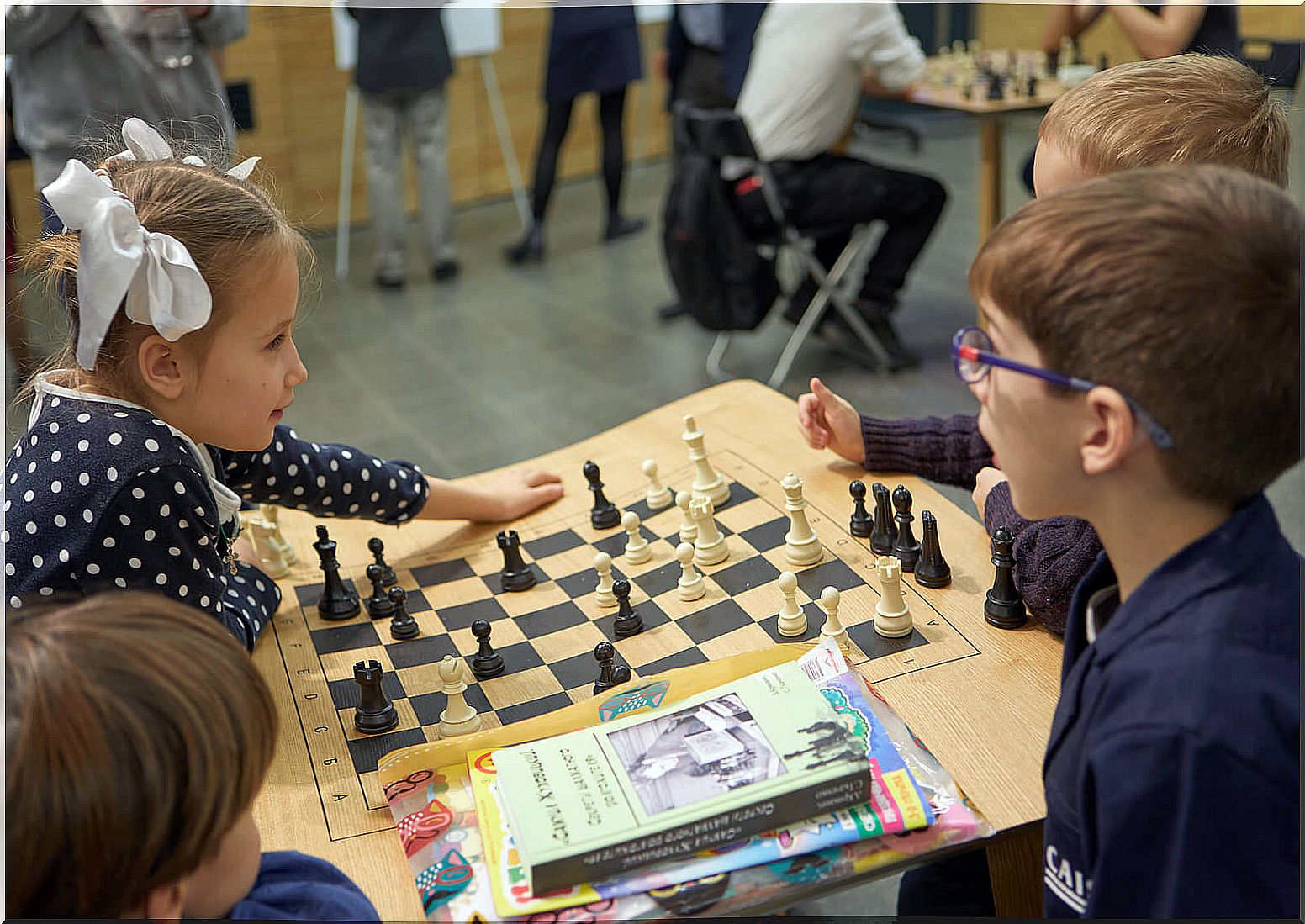 Child playing chess learning what healthy competitiveness is.