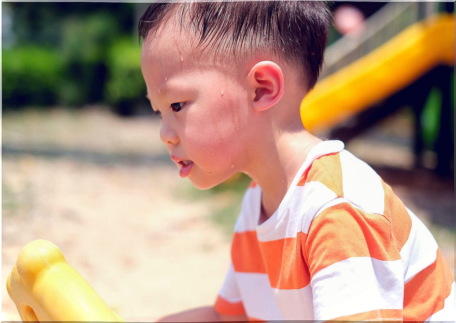 Boy sweating a lot because he is playing in the sun.