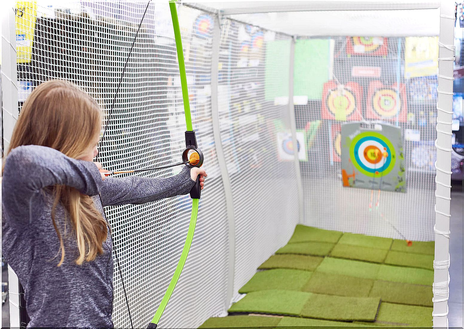 Teen girl practicing archery.