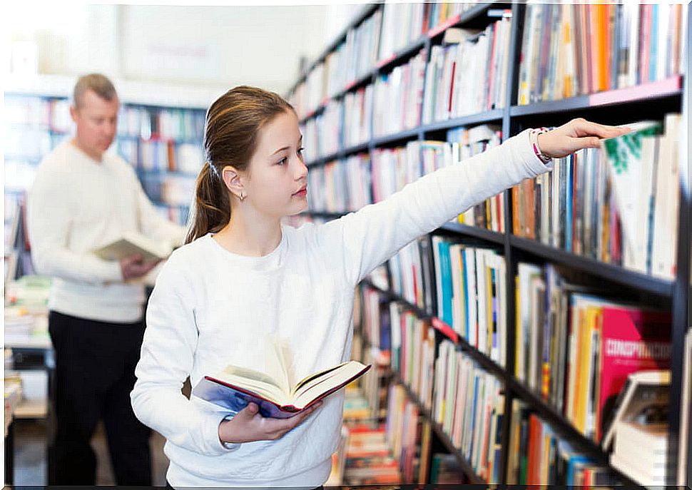 Girl in the library looking for books that have won the El Barco de Vapor Award.