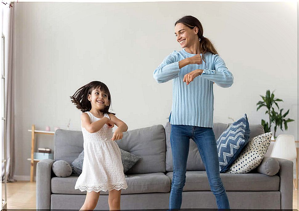 Mother dancing with her daughter to reassure her without using a tablet or mobile.