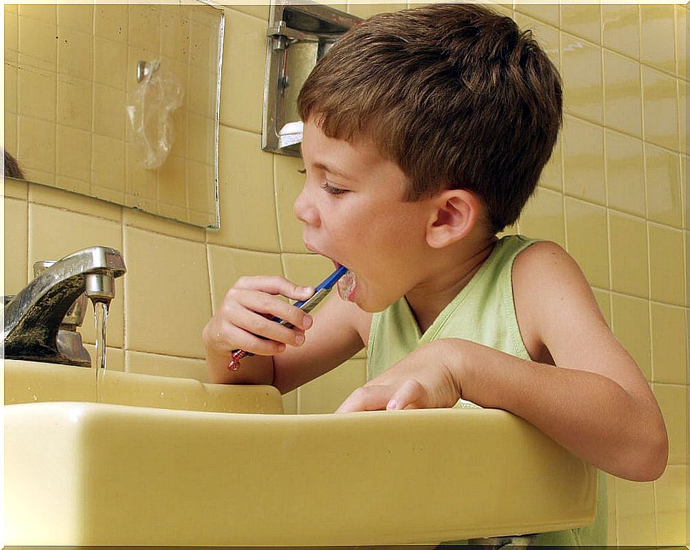 Child brushing teeth as part of his responsibilities due to his age.